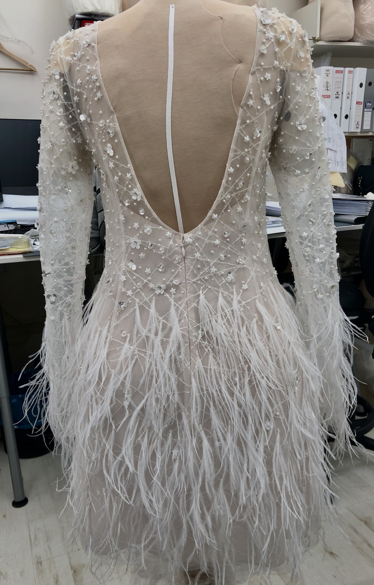 Hand-finished bridal dress with dimensional flowers, pearls and feathers